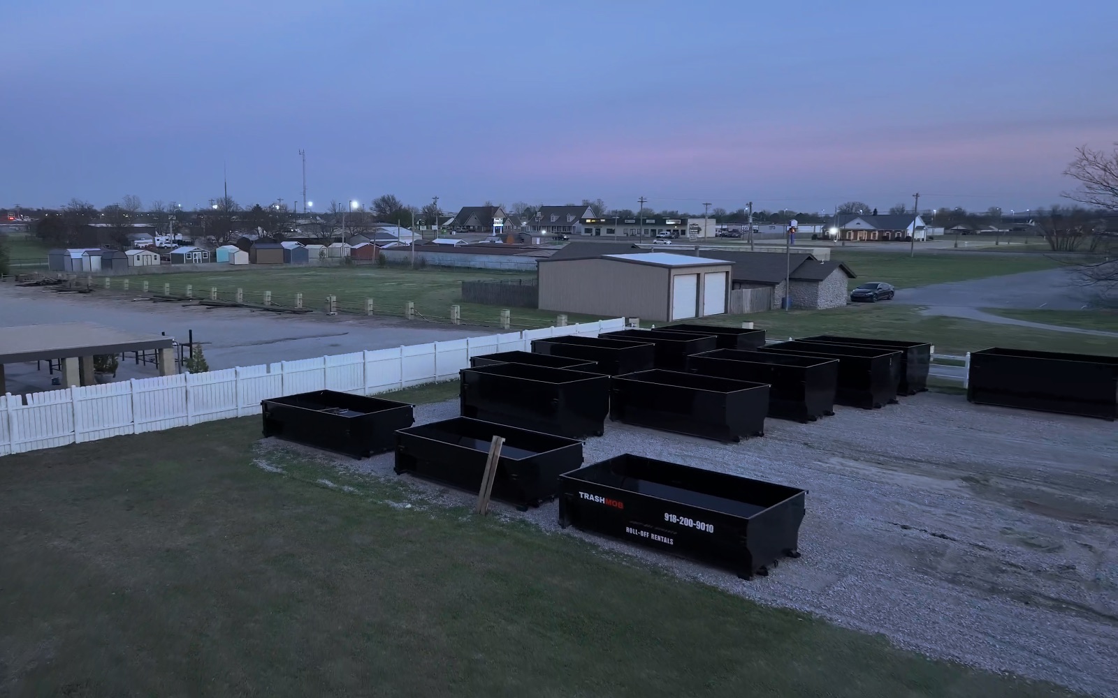 Rows of TrashMob roll-off dumpsters staged in the yard, ready for job sites